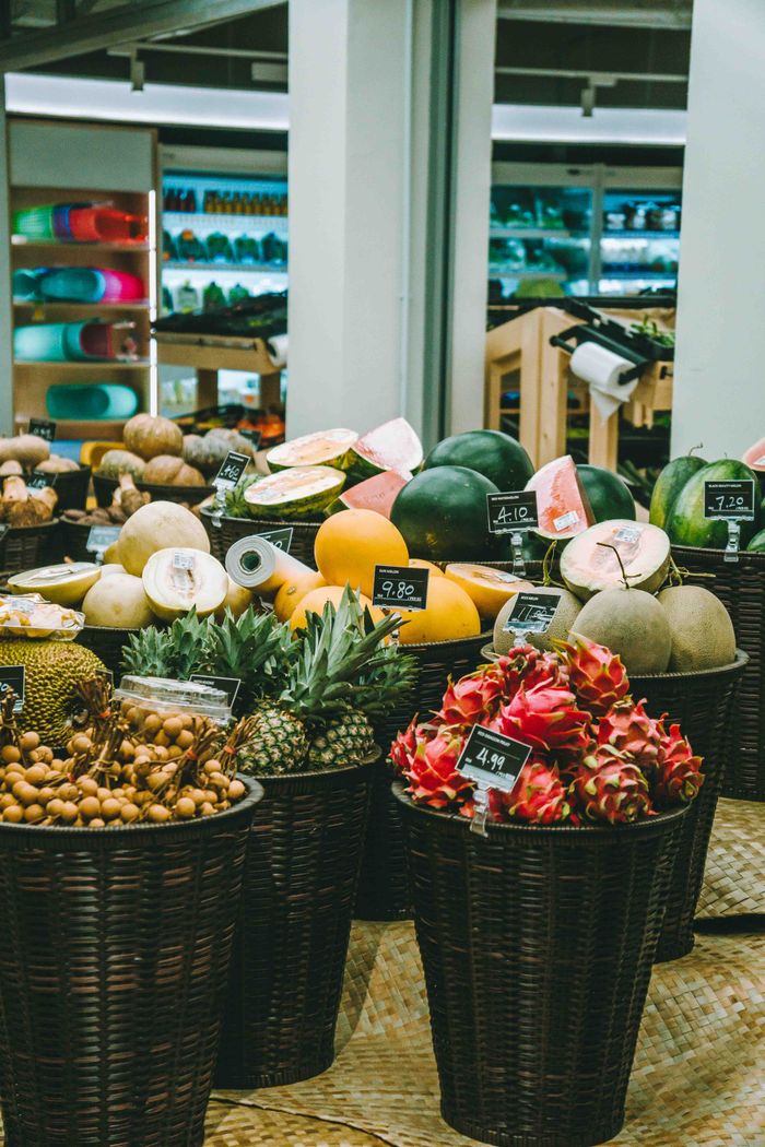Colorful assortment of tropical fruits in baskets at a Kuala Lumpur market.