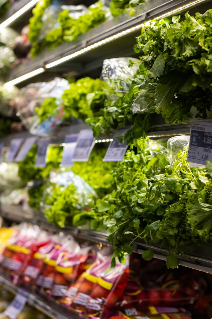 Fresh green vegetables neatly displayed on supermarket shelves, showcasing natural health options.